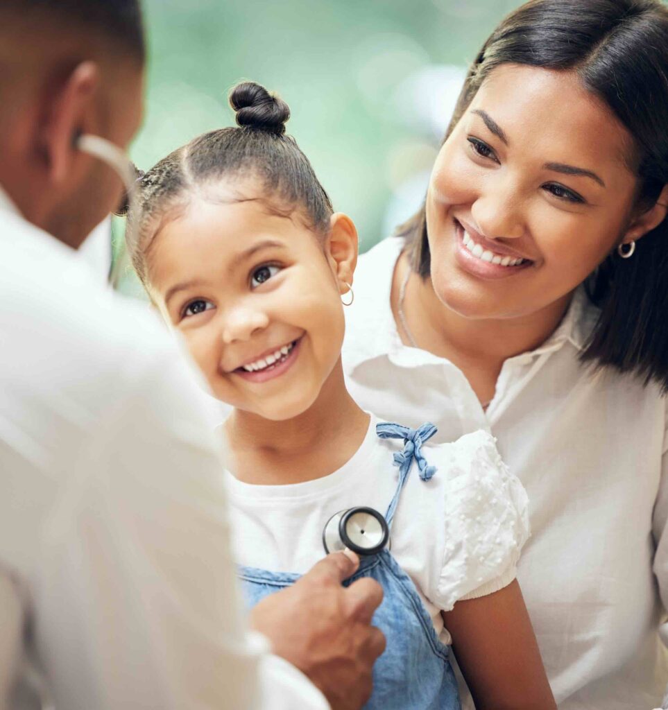 Female family doctor in Mississauga clinic checking mother and child.